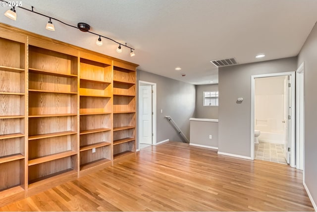 empty room featuring light wood finished floors, baseboards, visible vents, and recessed lighting