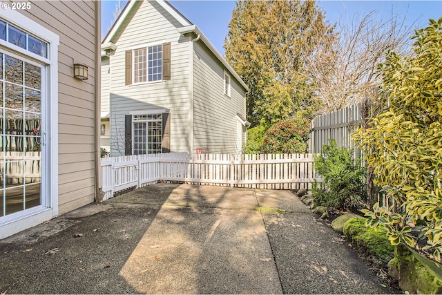 view of home's exterior with fence and a patio