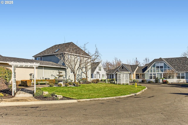 view of front of property featuring a residential view, a pergola, and a front yard