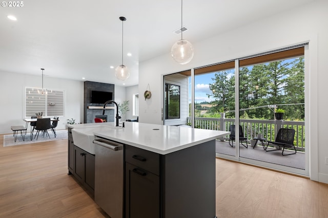 15625 NW Gooderham St, Portland, OR 97229 - kitchen with stainless steel dishwasher, light wood-style floors, light countertops, decorative light fixtures, and recessed lighting