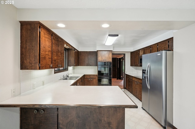 28040 SE Stark St, Troutdale, OR 97060 - kitchen with appliances with stainless steel finishes, a sink, light floors, a peninsula, and dark brown cabinetry