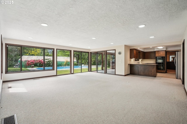 28040 SE Stark St, Troutdale, OR 97060 - unfurnished living room featuring baseboards, recessed lighting, a textured ceiling, and light carpet