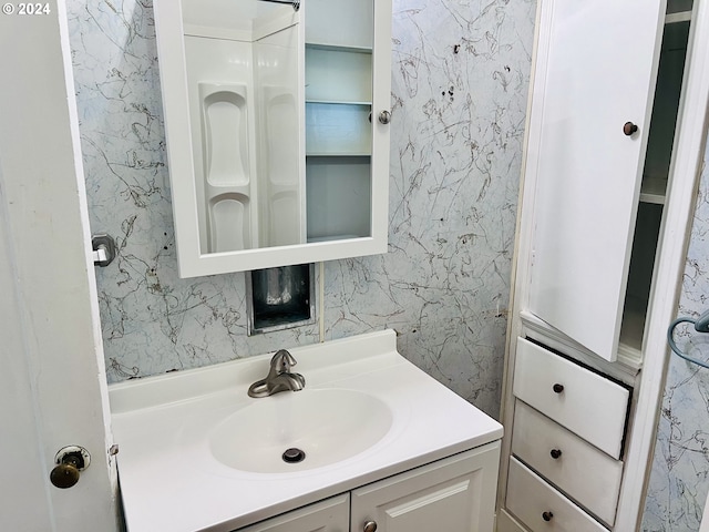 bathroom featuring vanity and wallpapered walls