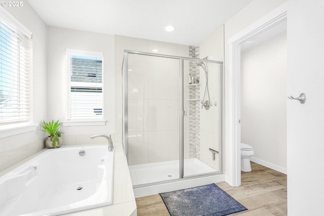 bathroom featuring shower with separate bathtub and toilet