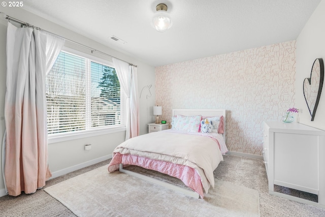 bedroom featuring light carpet and a textured ceiling