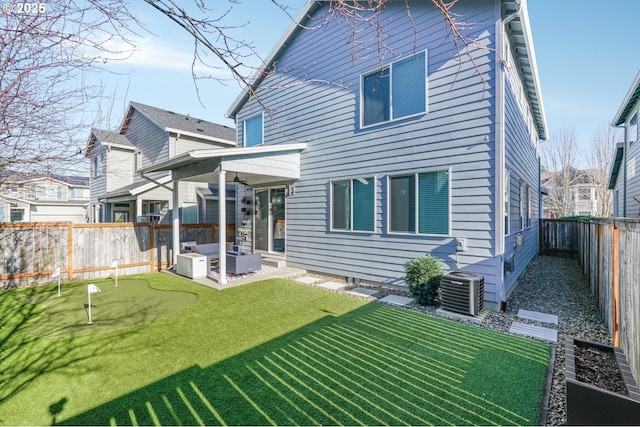 back of house with central AC, a yard, and a patio area