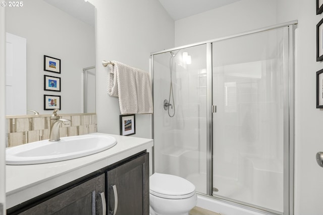 bathroom featuring walk in shower, vanity, and toilet