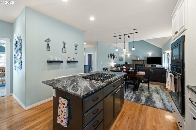 16420 SW Sienna Ln, Beaverton, OR 97007 - kitchen with black appliances, open floor plan, white cabinets, light wood-type flooring, and a kitchen island