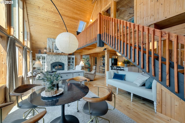 53461 Safe Rd, Bandon, OR 97411 - living room featuring high vaulted ceiling, a stone fireplace, wood finished floors, wood ceiling, and wood walls