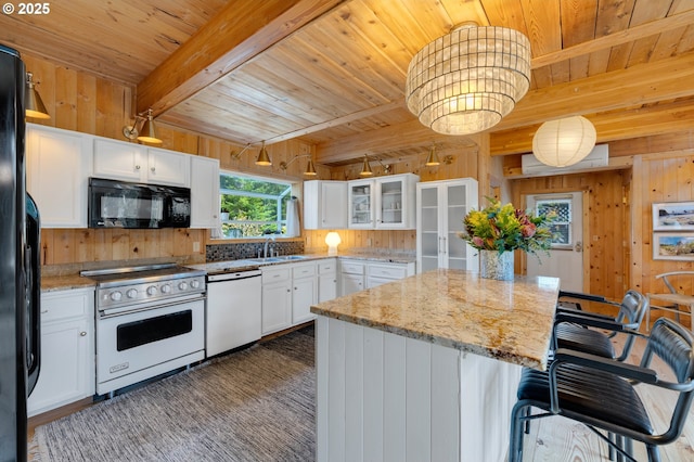 53461 Safe Rd, Bandon, OR 97411 - kitchen with black appliances, wooden ceiling, wood walls, and a kitchen island