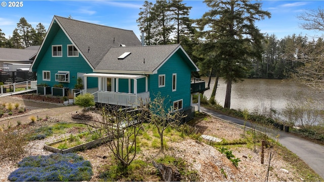 53461 Safe Rd, Bandon, OR 97411 - back of property featuring roof with shingles, a garden, and a water view