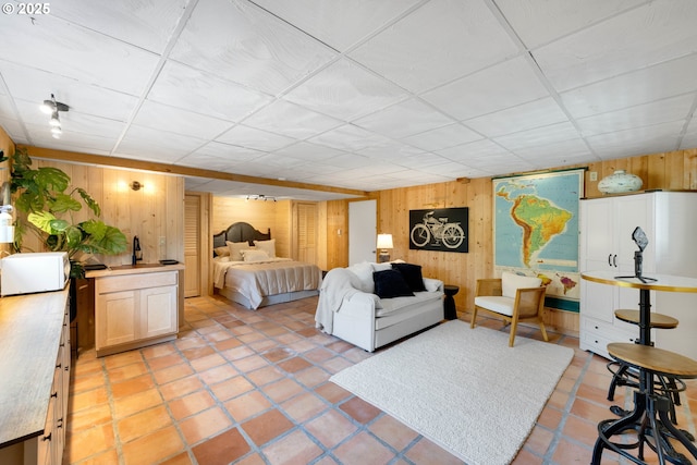 53461 Safe Rd, Bandon, OR 97411 - bedroom with wooden walls, a drop ceiling, and light tile patterned floors