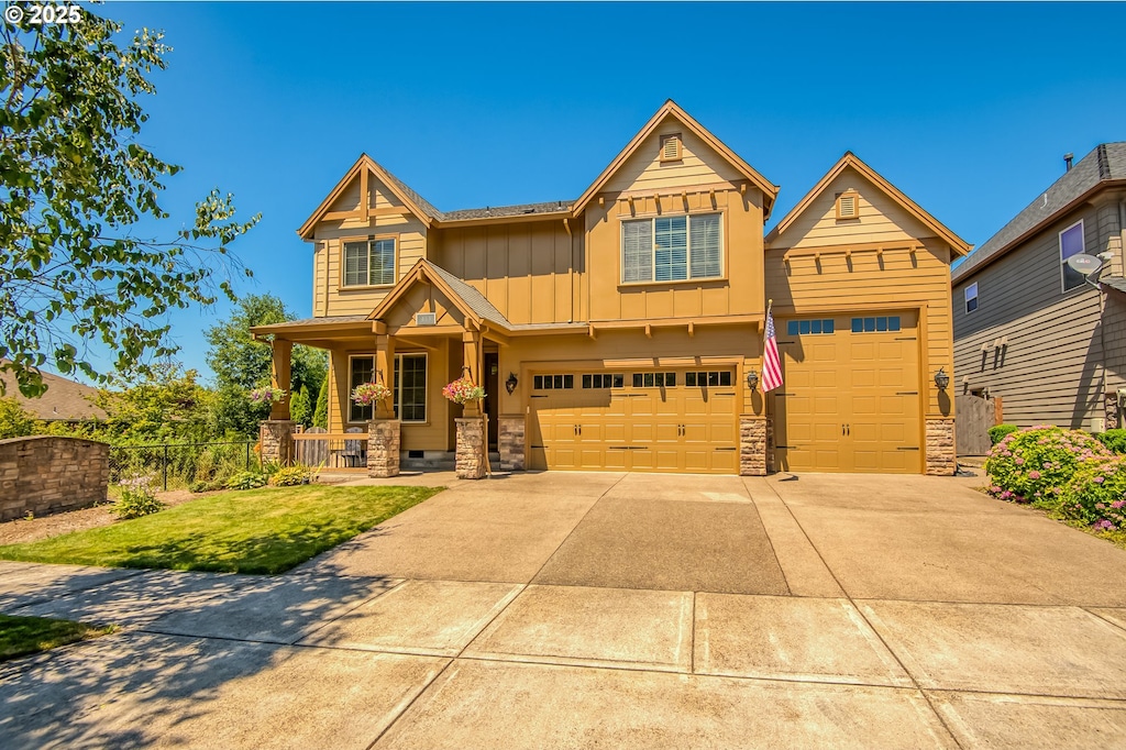 craftsman inspired home featuring a porch, a garage, and a front lawn