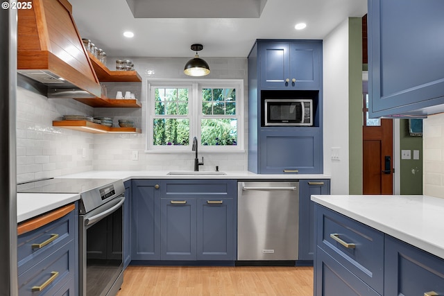21482 SW 92nd Ct, Tualatin, OR 97062 - kitchen featuring stainless steel appliances, a sink, blue cabinetry, custom exhaust hood, and recessed lighting