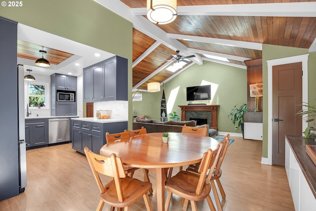 21482 SW 92nd Ct, Tualatin, OR 97062 - dining room featuring light wood-type flooring, wooden ceiling, ceiling fan, a fireplace, and baseboards