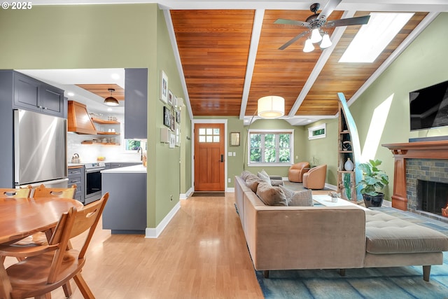 21482 SW 92nd Ct, Tualatin, OR 97062 - living room featuring a ceiling fan, light wood-style flooring, wood ceiling, baseboards, and a fireplace