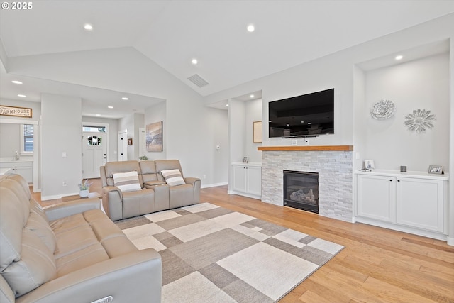 living area with recessed lighting, light wood finished floors, lofted ceiling, and visible vents