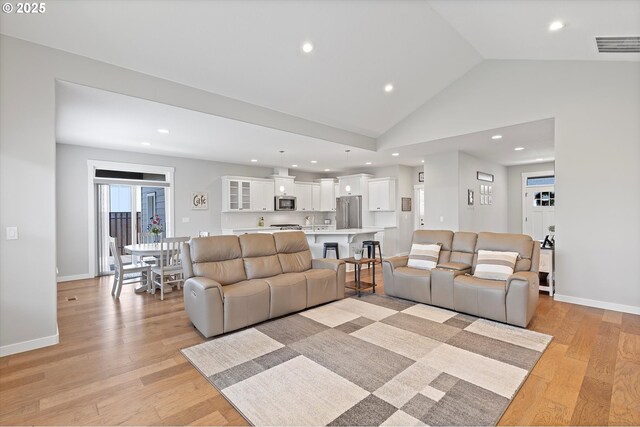 living room featuring light wood-style floors, recessed lighting, and visible vents