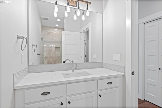 full bath featuring vanity, visible vents, and a stall shower