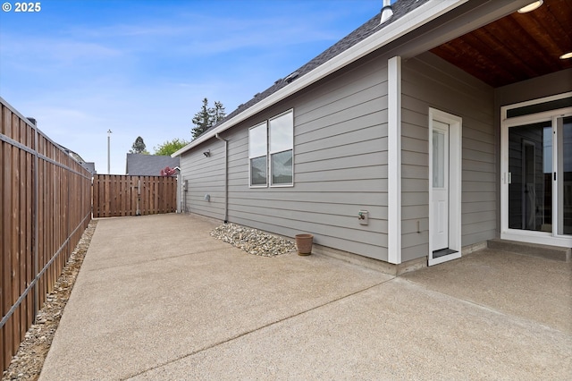 view of side of property with a patio and fence