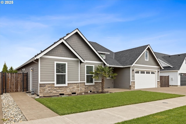 craftsman house with driveway, roof with shingles, fence, a front lawn, and stone siding