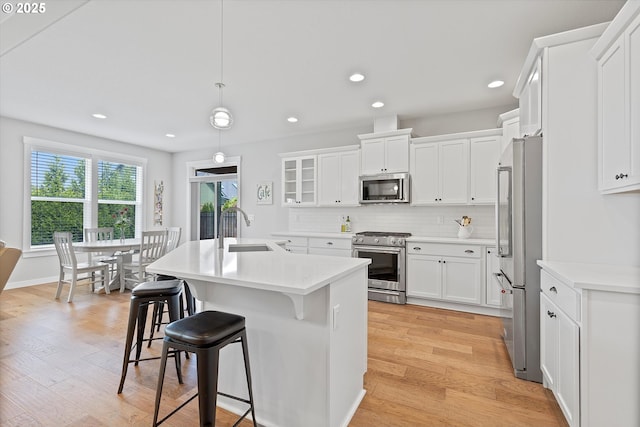 kitchen featuring light wood-style floors, a sink, white cabinetry, and appliances with stainless steel finishes