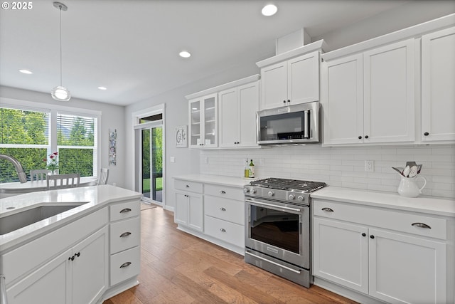 kitchen featuring a sink, appliances with stainless steel finishes, tasteful backsplash, and light countertops