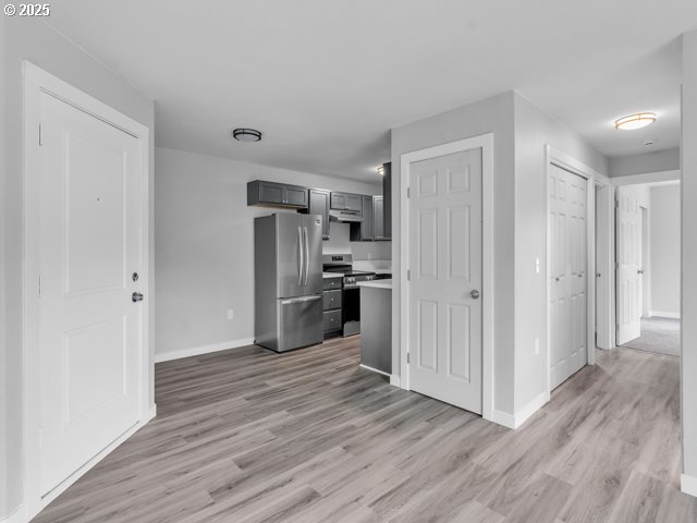 9257 SE Clinton St, Portland, OR 97266 - kitchen featuring stainless steel appliances, light wood-style floors, baseboards, gray cabinetry, and light countertops
