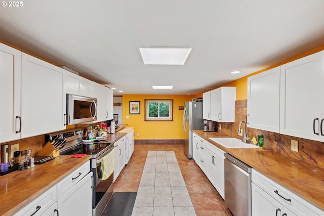 500 State St, North Bend, OR 97459 - kitchen with appliances with stainless steel finishes, a sink, decorative backsplash, white cabinets, and recessed lighting