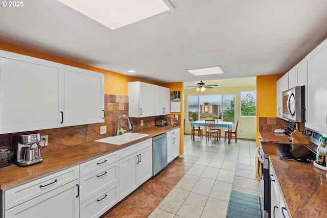 500 State St, North Bend, OR 97459 - kitchen with stainless steel appliances, a sink, tasteful backsplash, white cabinetry, and ceiling fan