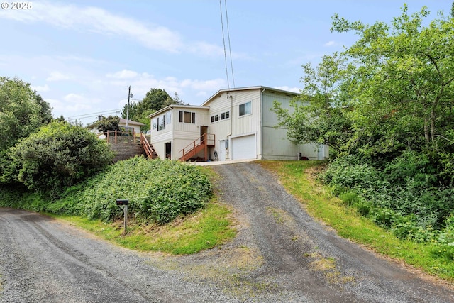 500 State St, North Bend, OR 97459 - view of front of house with stairs, an attached garage, and driveway