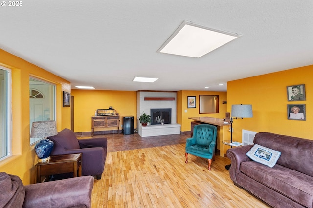 500 State St, North Bend, OR 97459 - living room featuring a brick fireplace, wood finished floors, and baseboards