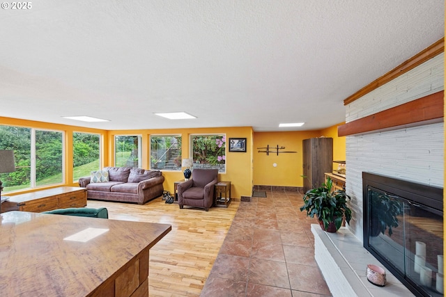 500 State St, North Bend, OR 97459 - living room featuring a brick fireplace, a textured ceiling, and baseboards