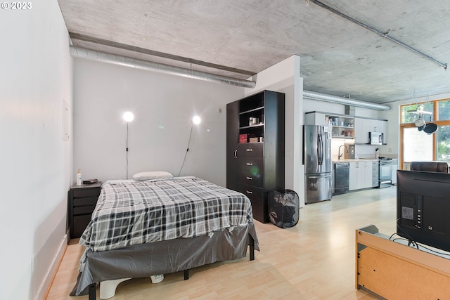 bedroom featuring sink, light hardwood / wood-style floors, and stainless steel fridge