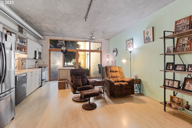 living area featuring sink, light hardwood / wood-style flooring, and ceiling fan