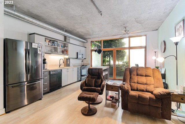 living room with expansive windows, ceiling fan, rail lighting, wet bar, and light hardwood / wood-style flooring