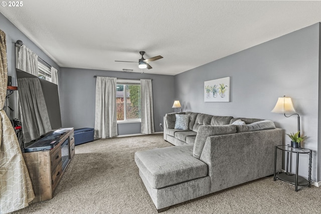 carpeted living area featuring ceiling fan and a textured ceiling