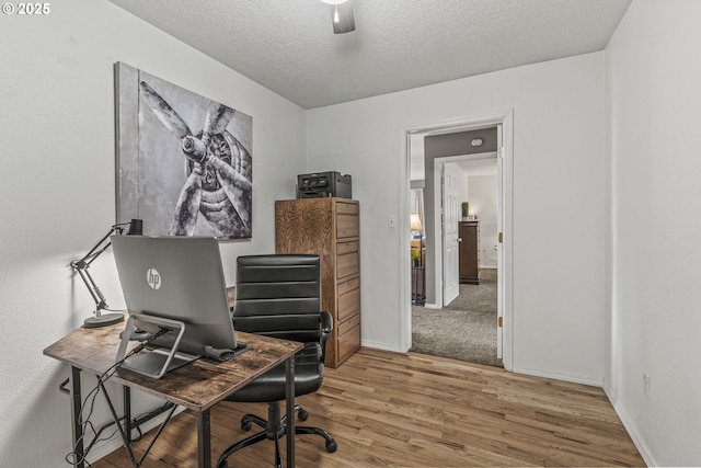 office featuring baseboards, a textured ceiling, a ceiling fan, and wood finished floors