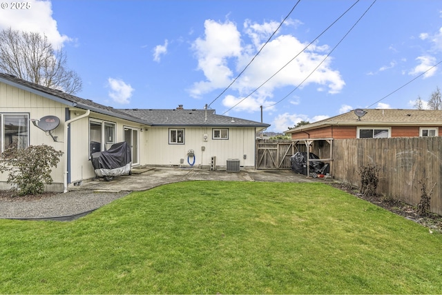 rear view of house featuring a patio area, a fenced backyard, central AC unit, and a lawn