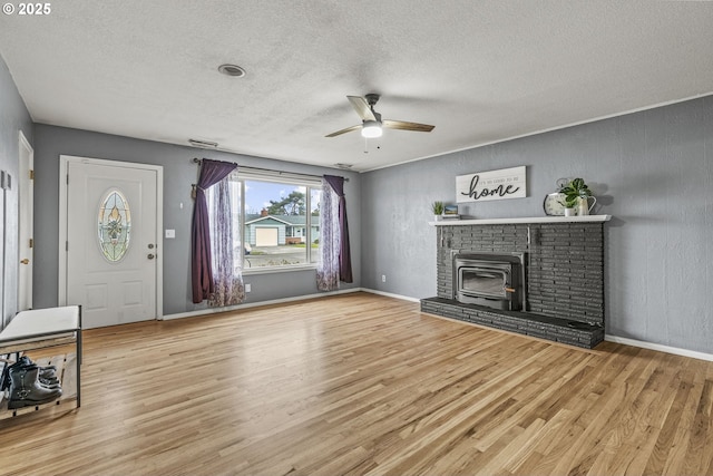 unfurnished living room with ceiling fan, a textured wall, a textured ceiling, and light wood-type flooring