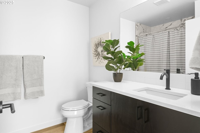 3530 NE 44th Ave, Portland, OR 97212 - full bath featuring vanity, toilet, wood finished floors, decorative backsplash, and baseboards