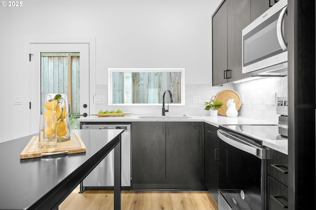 3530 NE 44th Ave, Portland, OR 97212 - kitchen featuring stainless steel appliances, a sink, decorative backsplash, light countertops, and light wood-style flooring