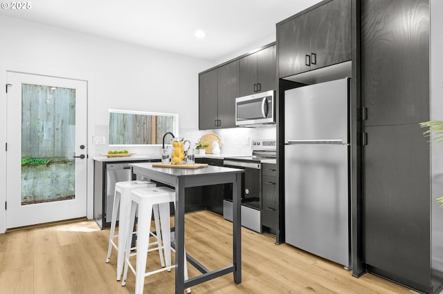 3530 NE 44th Ave, Portland, OR 97212 - kitchen with stainless steel appliances, light wood finished floors, recessed lighting, dark cabinets, and light countertops