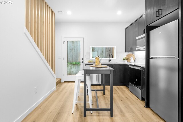 3530 NE 44th Ave, Portland, OR 97212 - kitchen with appliances with stainless steel finishes, light wood-style flooring, light countertops, dark cabinets, and recessed lighting