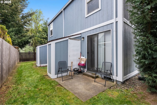 back of house with a fenced backyard and a lawn