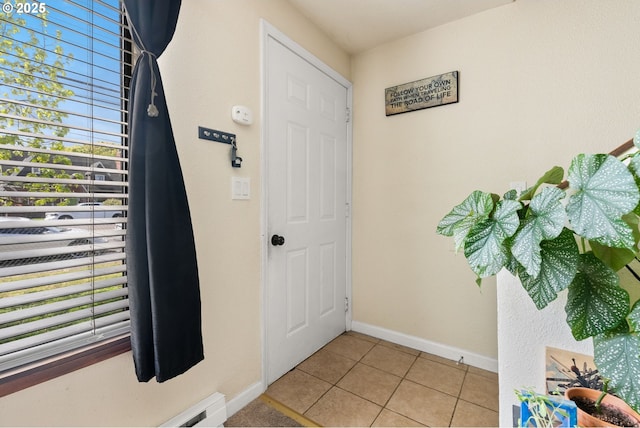 foyer entrance with light tile patterned floors and baseboards