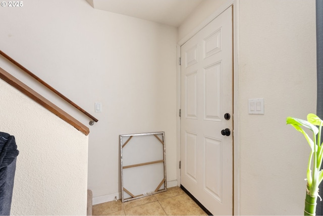 doorway featuring light tile patterned floors, stairs, and baseboards