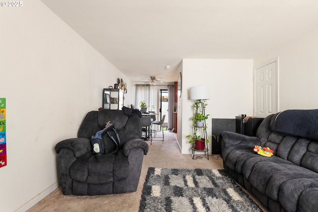 living room with baseboards, ceiling fan, and light colored carpet