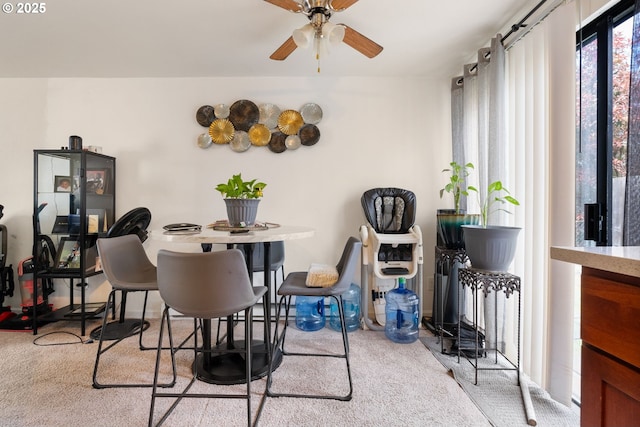 carpeted dining space with a ceiling fan