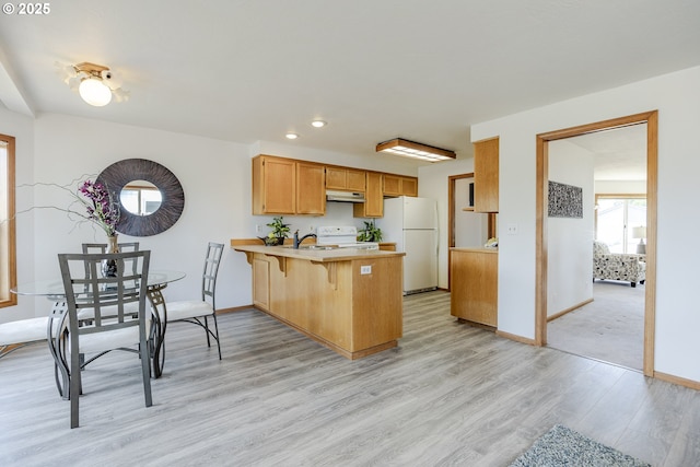 7324 B St, Springfield, OR 97478 - kitchen with white appliances, under cabinet range hood, a peninsula, light countertops, and light wood-style flooring
